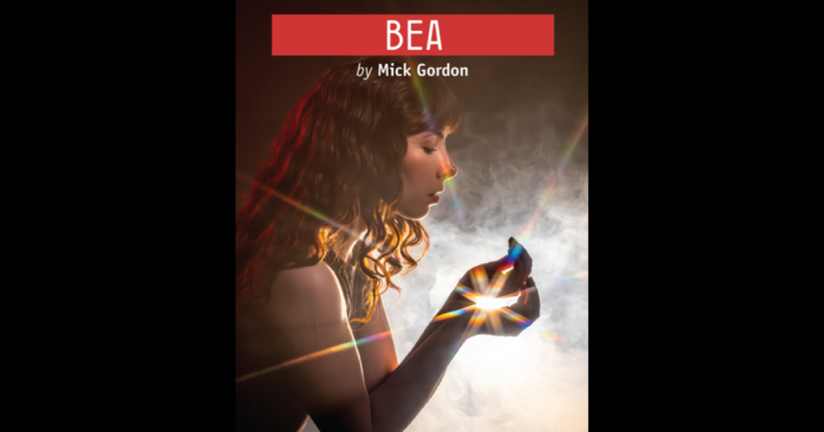 Poster for Bea at Shadow Theatre. A woman with curly brown hair stands stands in profile holding up a glowing light in her hands in front of her of 